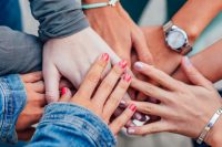 Woman to Woman Retreat; image of many hands clasped together, affirming one another